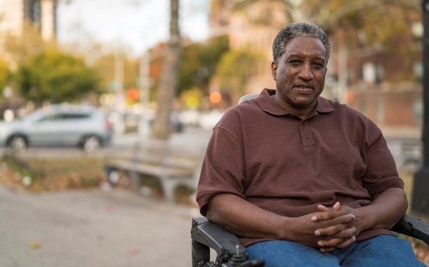 man sitting in wheelchair in city